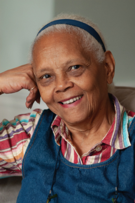Portrait of Quandra Prettyman smiling with her head leaning on her hand.